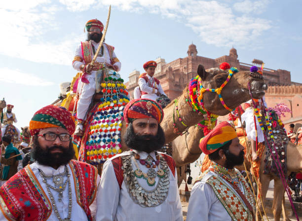 Bikaner, Rajasthan, India - January 11, 2020: Indian warriors in national clothes with weapon poses for a photo during Camel festival in Rajasthan. The Camel Festival begins with a colourful procession of bedecked camels. camel festival