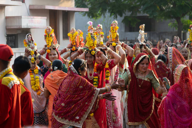 Rajasthan, India - 3 April 2022, Hindu married bride, women celebrating gangaur teej festival. Isar, gauri mata parvati, shiva, idols, dance, music, fasting, jewellery, tradition clothes, marwari, joy gangur festival